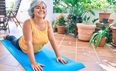 Older woman stretching on yoga mat