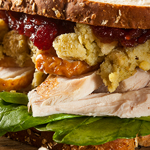 Sandwich on wheat bread with turkey, stuffing, cranberry sauce, sweet potato and lettuce