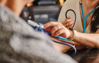 Provider listening to patient's heart with stethoscope