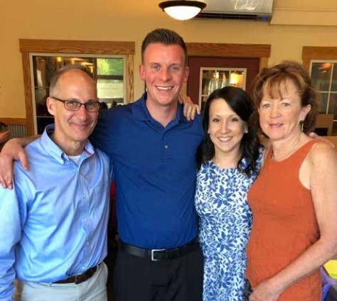 katie eicher poses for a photo with her family
