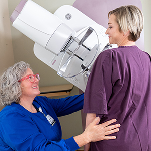 Mammography specialist with patient in front of mammography machine