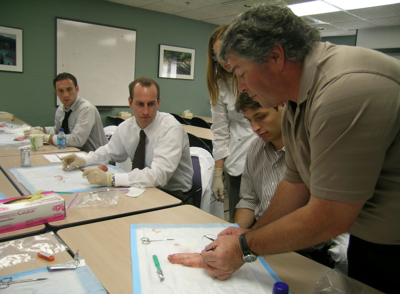 Medical students suturing pigs feet