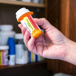 Hand holding medication bottle