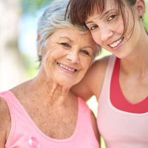 Two women wearing pink and embracing