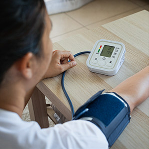 Person using home blood pressure monitor