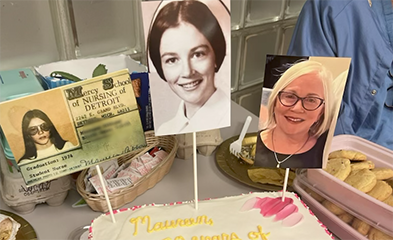 Table with photos and cake celebrating Maureen McLeod's 50 years in nursing
