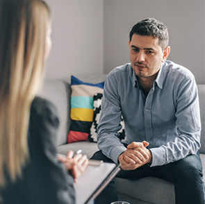 Young man speaking with therapist in office
