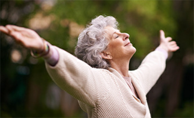 Woman standing with arms outstretched and eyes closed