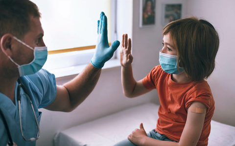 Healthcare provider high-fiving young patient