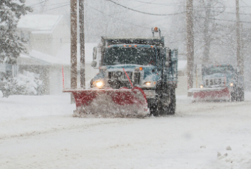 Plow trucks driving in heavy snow
