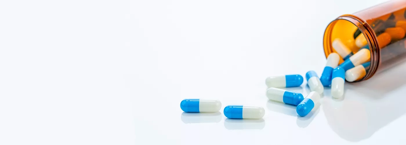 Overturned prescription bottle with pills spilling out